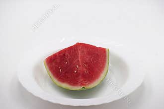 Fresh watermelon slice placed on a white plate for a refreshing summer snack option