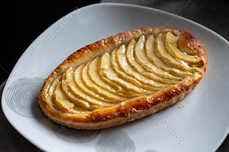 French fresh baked sweet puff pastry with fresh apple fruits in sirup in confectionery shop