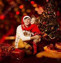 Christmas family. Father and Daughter Child under Xmas tree, red