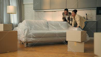 Happy satisfied couple home owners moving in new house relocation African American family move couch buy furniture sofa