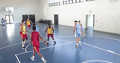 Basketball players in action on indoor court, competing with intensity and focus