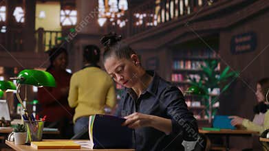 Professional author and librarian working on new notes in a public library