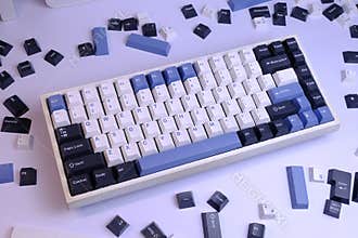 Close Up Modern 75% Layout Mechanical Keyboard with White, Blue, and Black Keycaps on a Clean White Desk