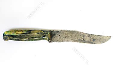 Vintage knife with a worn, rustic blade and a mottled green and yellow handle. Isolated on white, this image evokes themes of age
