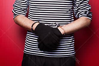 Criminal hands locked in handcuffs. Close-up view
