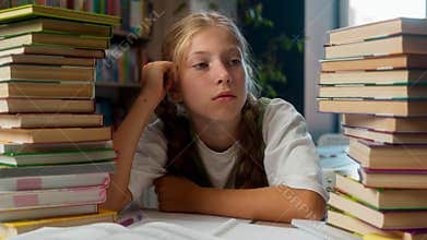 Lazy naughty tired bored Caucasian exhausted little girl school kid child schoolgirl learner pupil student sit desk