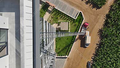 Aerial View: A lift system carefully moves furniture to upper floors through a balcony on a busy moving day.