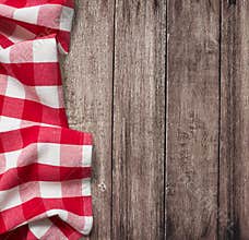 Old wooden table with red picnic tablecloth