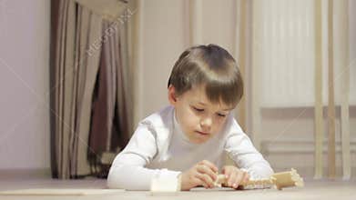 Little boy collects the designer on the floor