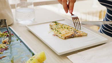 Woman Picking And Dividing The Last Slice Of Swordfish