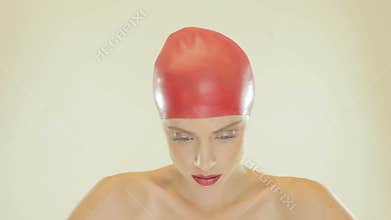 Blonde woman wearing red swimming cap