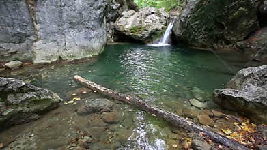 Waterfall and lake with clear water in wild nature