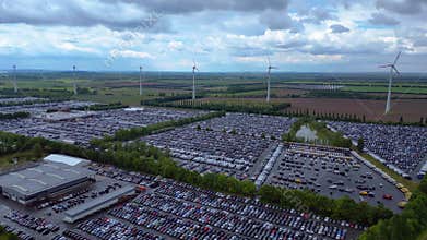 Large parking lot full of cars near wind farm. Best aerial view flight drone