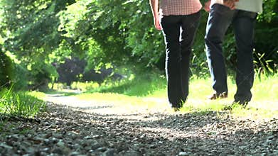 Close Up Of Couple's Feet Walking Along Countryside Path