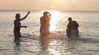 Silhouette Of Multi Generation Family Having Fun In Sea