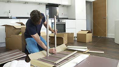 Man Putting Together Self Assembly Furniture In New Home