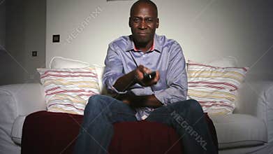 Mature African American Man On Sofa Watching TV