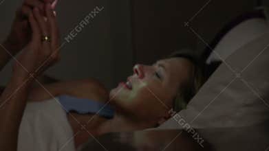 Middle Aged Couple In Bed With Woman Woken By Phone Message