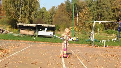 Toddler Exploring with Pink Scooters in Autumn Park