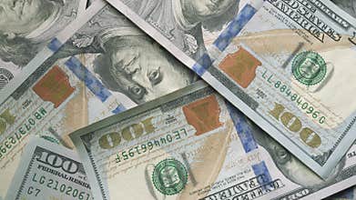 A close up view of multiple us dollar bills stacked neatly together, arranged in a pile