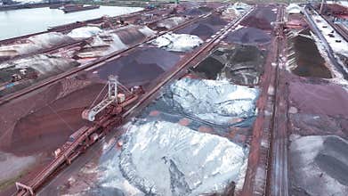 Flying over industrial port and warehouse for fossil fuels, coal and ore in the open air.