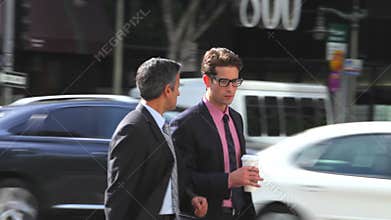 Two Businessmen Chatting Walking Along Street