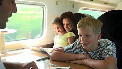 Family Relaxing On Train Journey