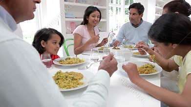 Multi Generation Indian Family Eating Meal At Home