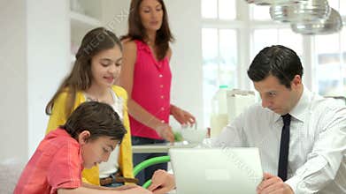 Family Having Breakfast Before Husband Goes To Work