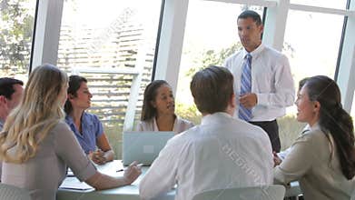 Businesspeople Seated Around Table Having Meeting
