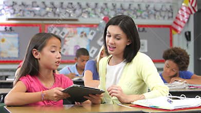 Teacher And Pupil Using Digital Tablet In Class