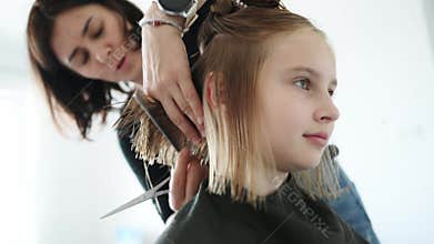 Hairdresser Cutting Hair To Little Girl