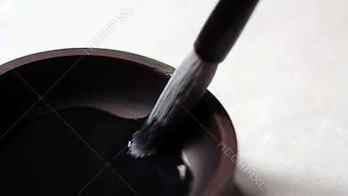 Brush dipping in ink