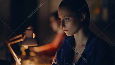 Focused entrepreneurs overtime work in dark coworking closeup. Two programmers