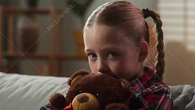 Sad Caucasian child girl hugging toy Teddy Bear sadness upset emotion frustrated lonely kid daughter looking at camera