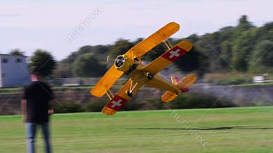 Bucker Bu 133 Jungmeister RC model performing low altitude aerobatics with smoke