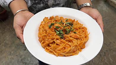 Blushing spaghetti with chicken served in a white plate in India