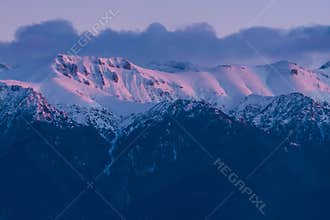 Carpathian Ridge Covered by Snow and Clouds at Sunset