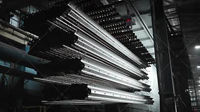 Heavy steel parts in a large industrial plant being loaded into a galvanizing bath. Chemical treatment of parts.