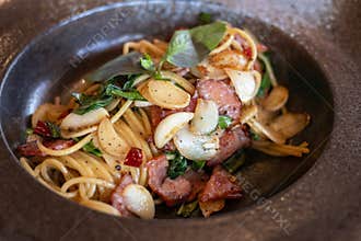 Spaghetti aglio e olio Traditional Italian pasta with dried chili, garlic, olive oil and crispy bacon flakes on top. Top view
