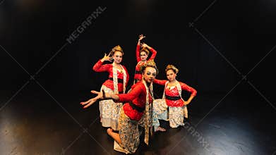 a group of traditional Indonesian dancers look elegant and beautiful when wearing red costumes in front of the audience