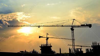 Time lapse sunset and silhouette crane in construction site