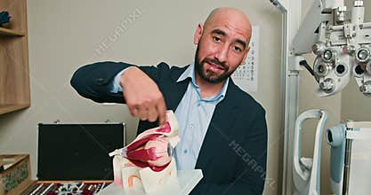 Optometrist Explains Eye Anatomy with Model in Ophthalmology Clinic
