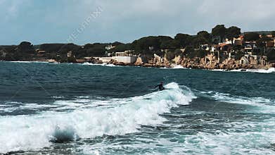 Surfer riding, turning with spray on blue ocean wave and falling in water, surfing ocean lifestyle. Slow motion. Concept