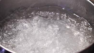 salt is added to boiling water in a saucepan.