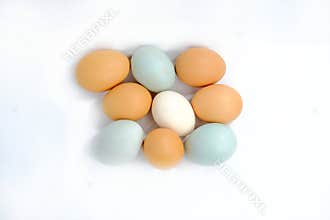 Multicolored village chicken eggs and soybean on white.