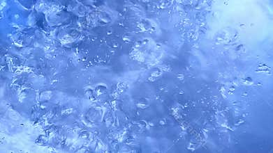 Closeups of bubbles forming and rising highlighting the dynamic transformation of water as it heats