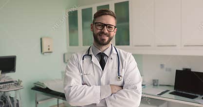 Male cardiologist posing in examination room, looking at camera
