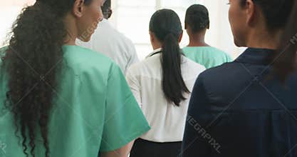 Diverse Medical Team Walking and Talking in Hospital Hallway: Collaboration and Care in Modern Healthcare