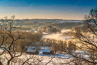 Winter sunrise with mist and wooden houses